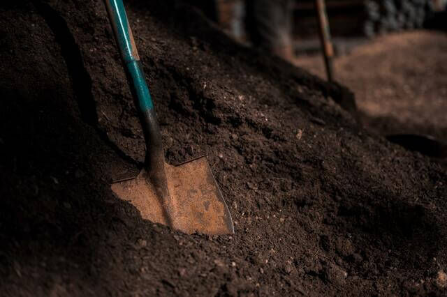 Small mound of soil with a shovel standing up in it